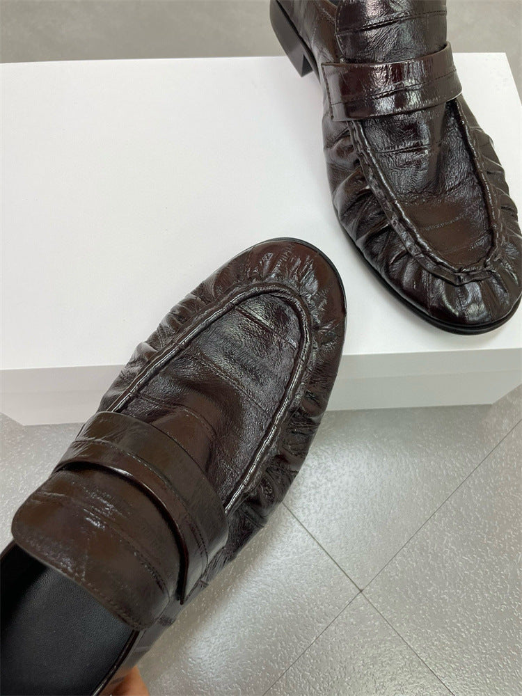 Eel skin loafers for women by Rossie Viren featuring sleek black leather shoes with a classic slip-on design.