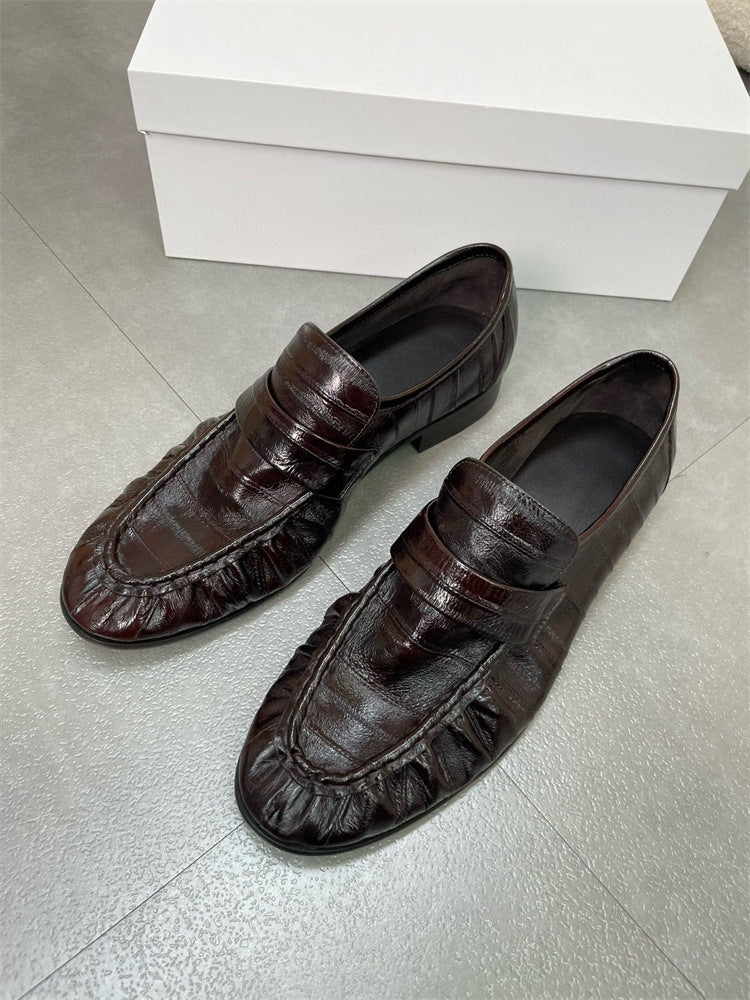Eel skin women's loafers by Rossie Viren, featuring sleek black slip-on shoes with textured eel skin finish and low heel.