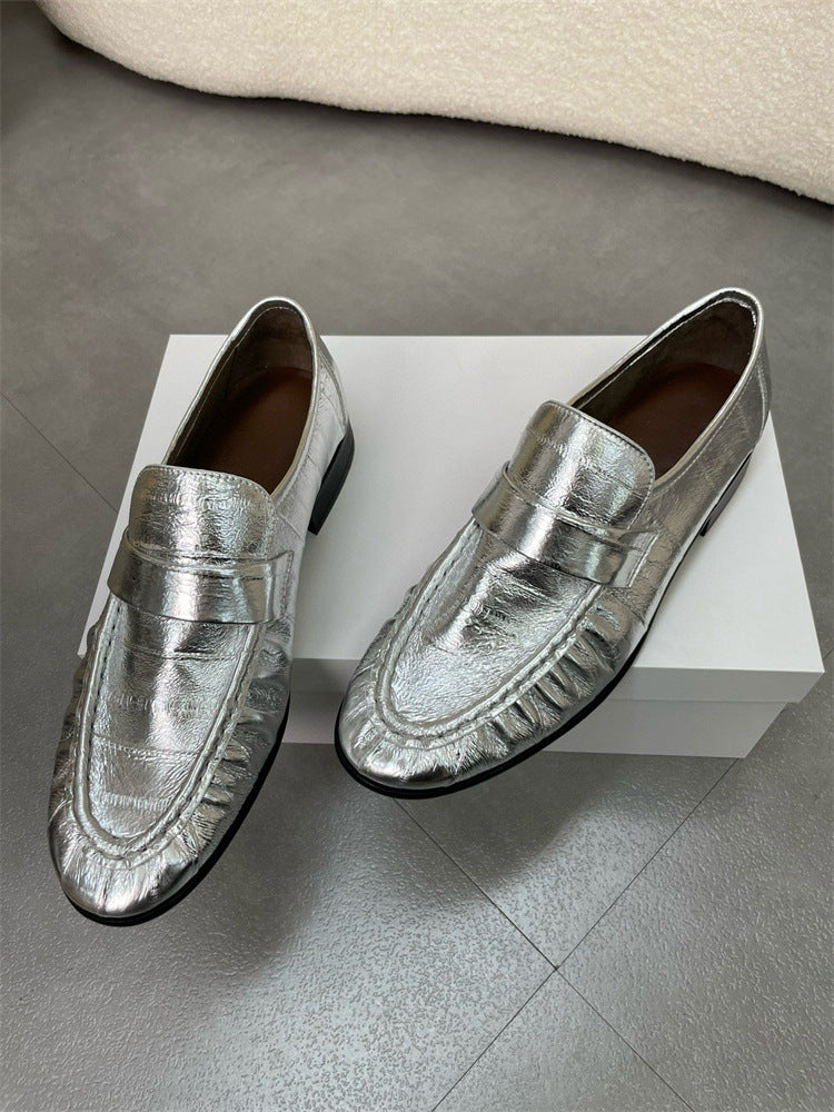 Eel skin loafers for women by Rossie Viren, showcasing sleek black slip-on shoes with a smooth, shiny finish.