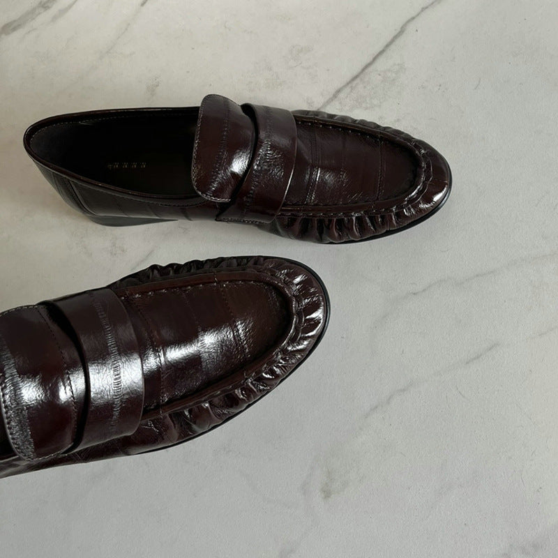 Eel skin loafers for women by Rossie Viren, featuring sleek black shoes with a smooth finish and stylish slip-on design.