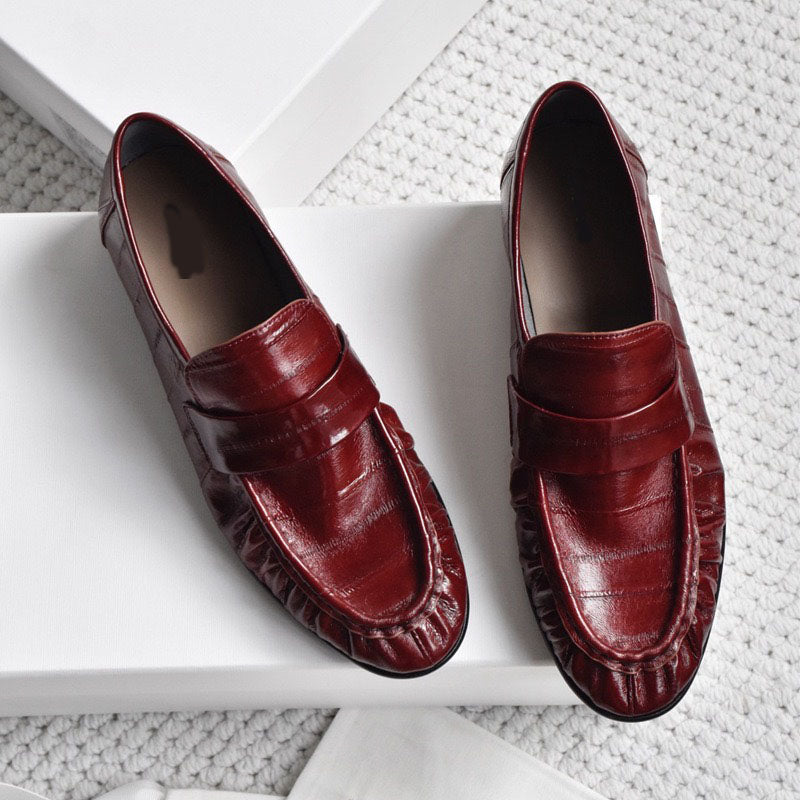 Eel skin loafers for women in black from Rossie Viren, featuring a sleek slip-on shoe design with a smooth, glossy finish.