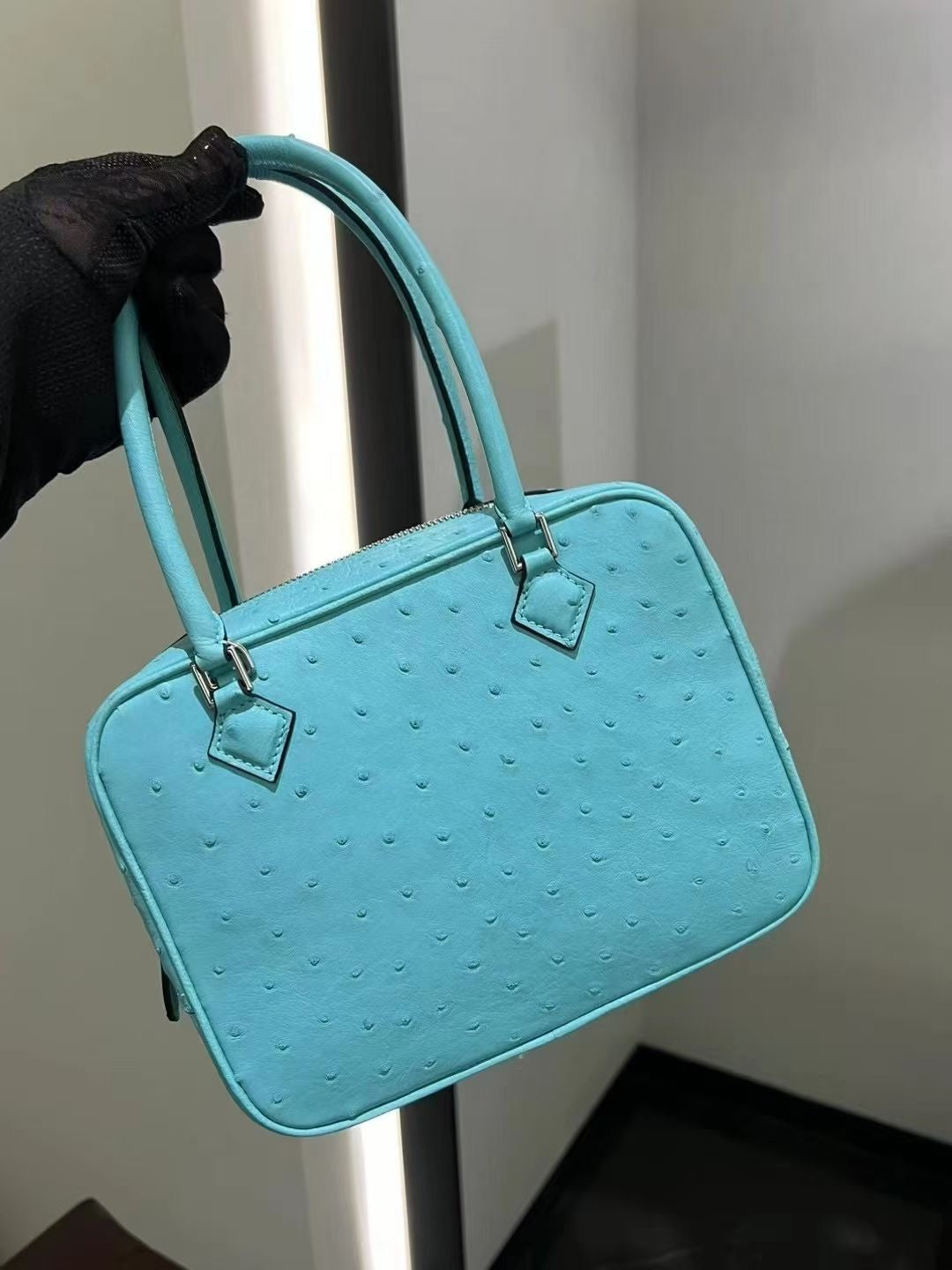 Women’s genuine ostrich skin leather handbag with top handle by Rossie Viren, showcasing smooth, textured leather and elegant design.